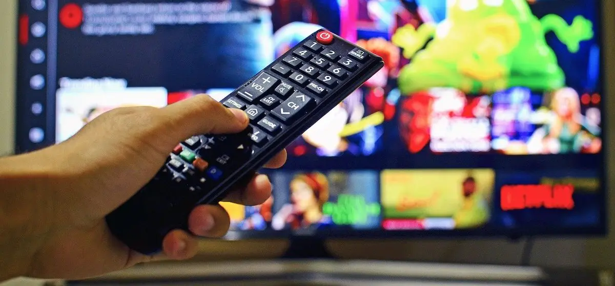 Adding the right music to your marketing video: man with remote in front of TV