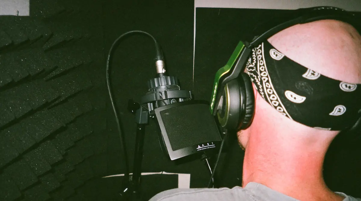 how to prepare a voice over script: man standing in front of microphone