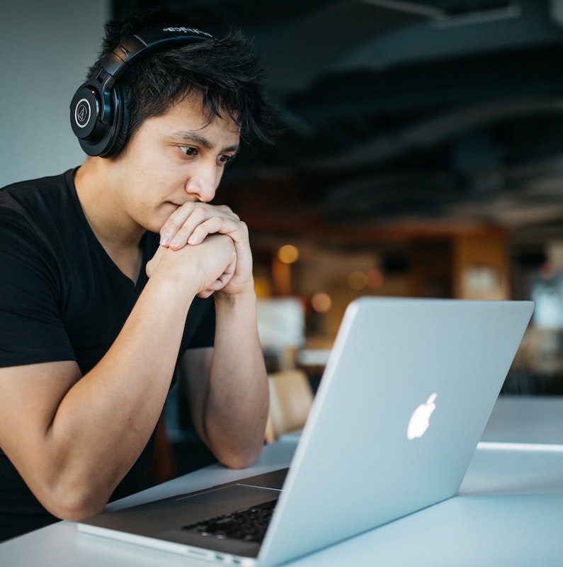 Hiring a voice actor: man sitting in front of a laptop with headphones on