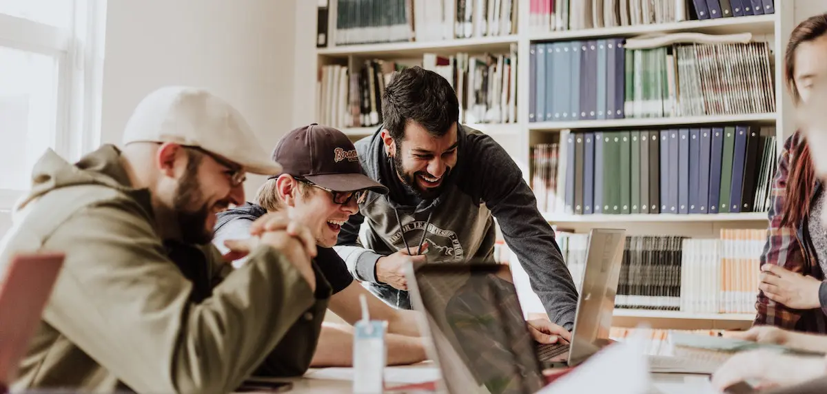 image of people around a table looking at social media