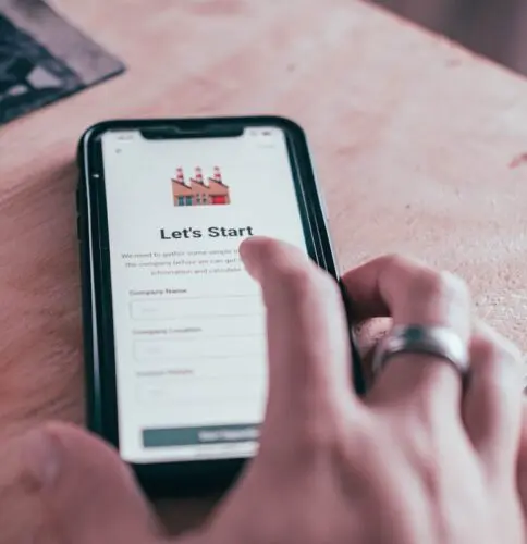 Customer retention tips: image of a man's hand and a online form displayed on a mobile phone