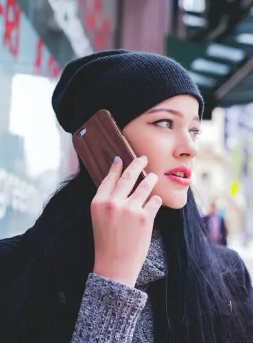 Customer retention tips: image of woman listening to a message on a mobile phone