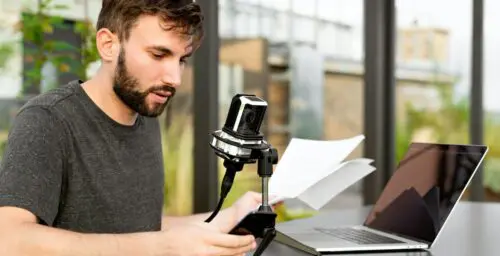 Most out of a voice actor: image of a man sitting with a mic in front of his laptop