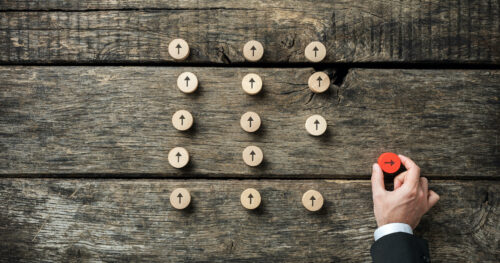 Make your business stand out: image of a hand moving a red peg away from other white pegs