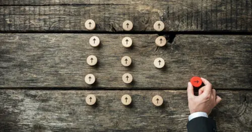 Make your business stand out: image of a hand moving a red peg away from other white pegs