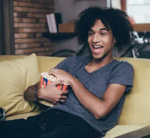 Humor in ads: image of a man watching a funny ad on television