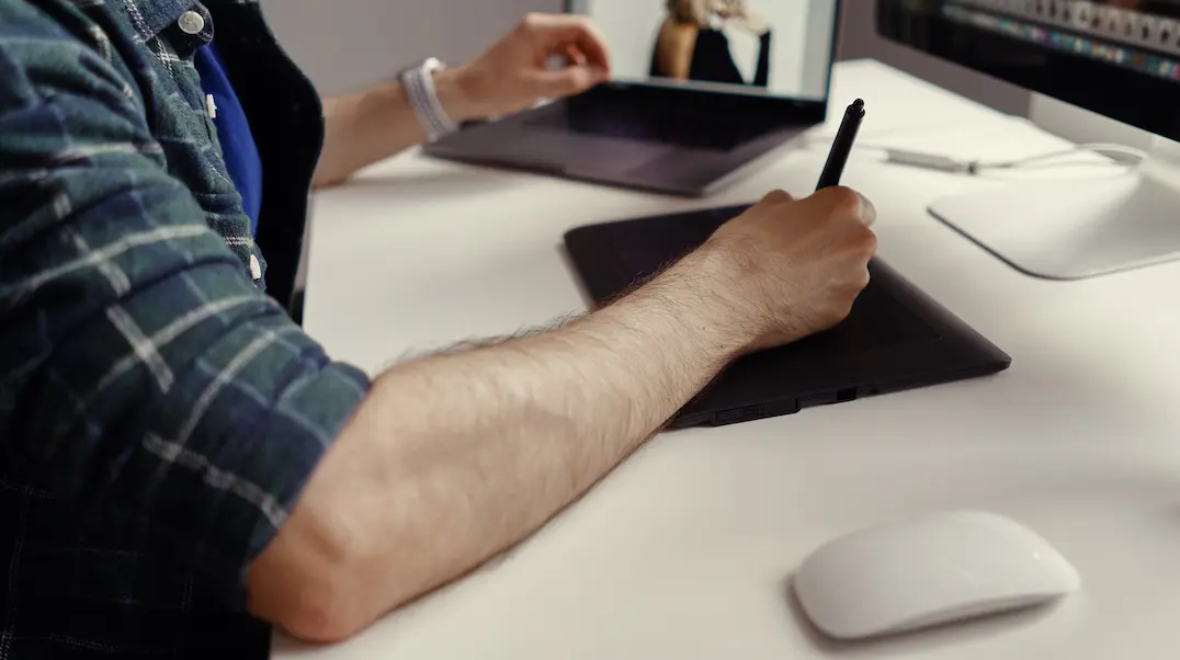 Interactive content: image of a man using a tablet and a laptop.
