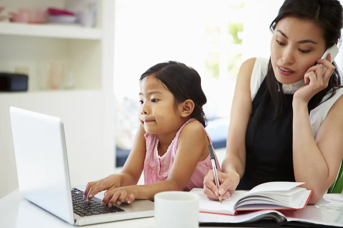 Work from home: woman working with her daughter next to her desk