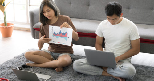 Work from home: image of couple sitting on the floor in front of their laptops