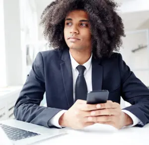 Messaging: image of a young man typing a message on his cell phone
