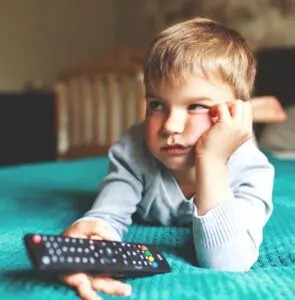 Videos: image of a bored young boy watching a video on a TV