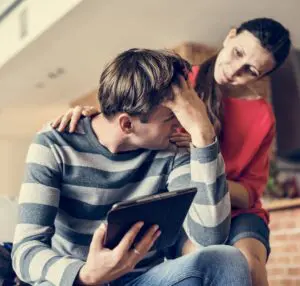 Social Media: Image of a man being consoled by a woman.