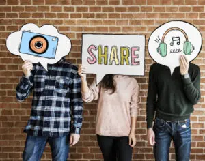 Small business: three young people holding up social media cards