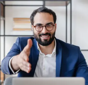Small business: a small business owner smiling and stretching out his hand.