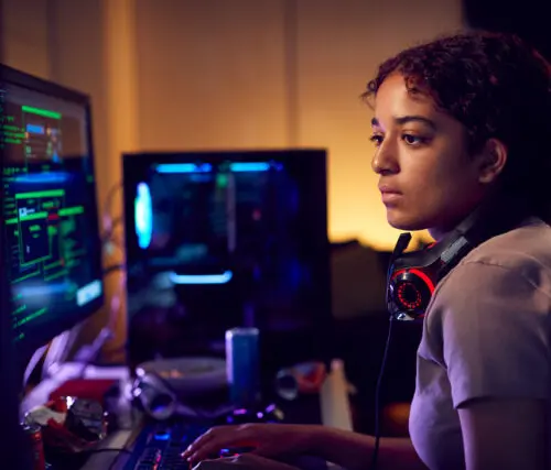 Penetration test: young female hacker sitting in front of a computer screen